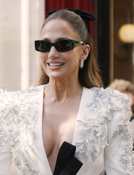 Jennifer Lopez smiling in sunglasses and an embellished white jacket